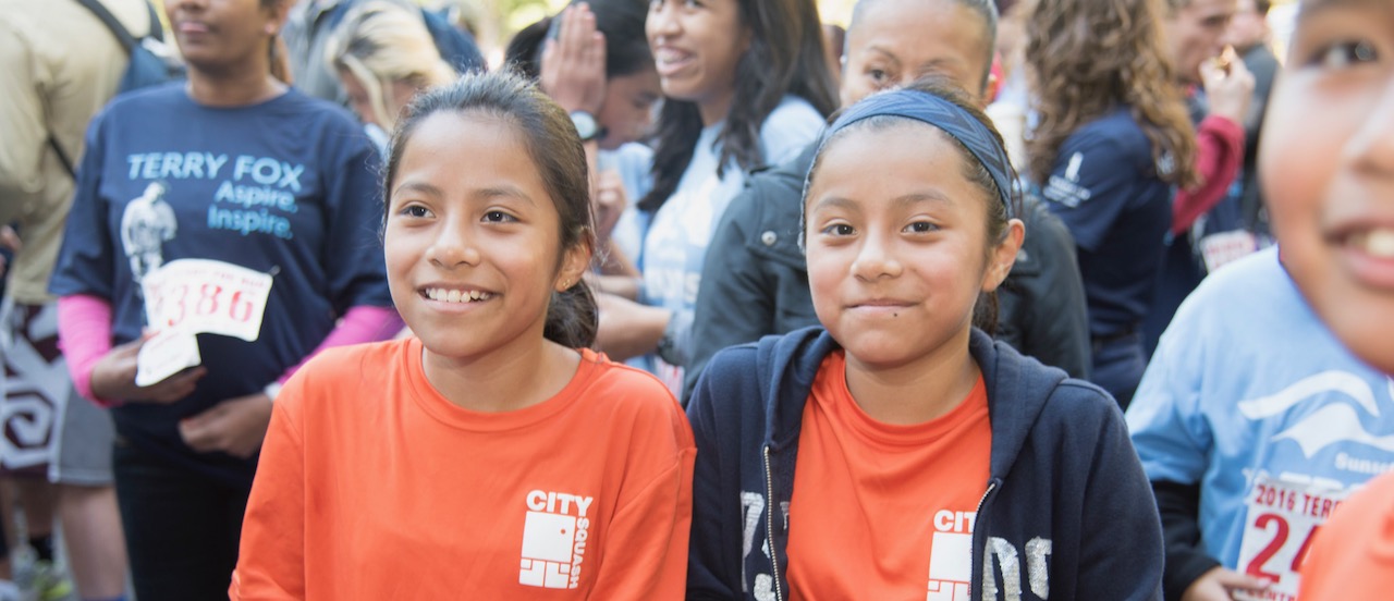Two young girls smiling at the Terry Fox Run event in Central Park
